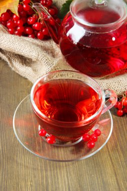 Bodegón con té de viburnum en servilleta de tela de saco, sobre fondo de madera