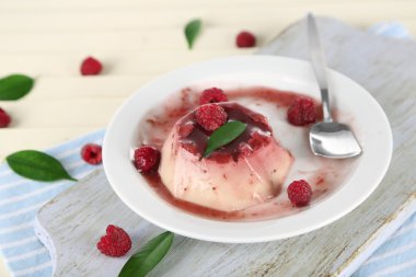 Panna cotta ahşap zemin üzerinde frambuaz sos ile