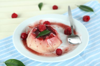 Panna cotta ahşap zemin üzerinde frambuaz sos ile