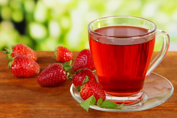 Delicioso té de fresa en la mesa sobre fondo brillante — Foto de Stock