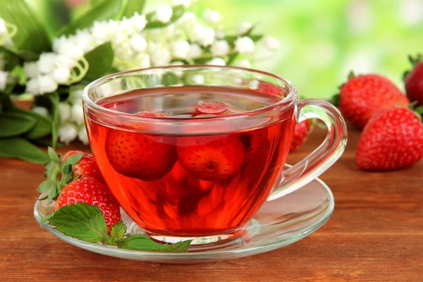 Delicious strawberry tea on table on bright background — Stock Photo, Image