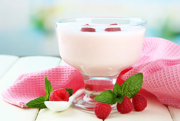 Heerlijke yoghurt met bessen op tafel op lichte achtergrond — Stockfoto