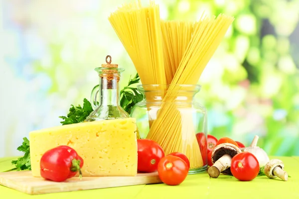 Massa com óleo, queijo e legumes em mesa de madeira sobre fundo natural — Fotografia de Stock