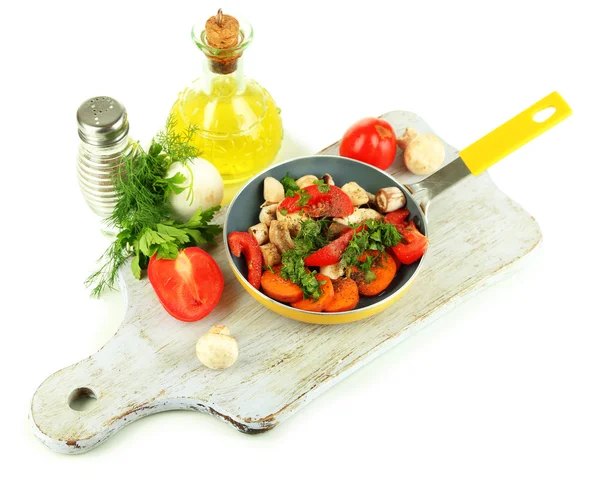 Skivade färska grönsaker i pannan på träplatta isolerad på vit — Stockfoto