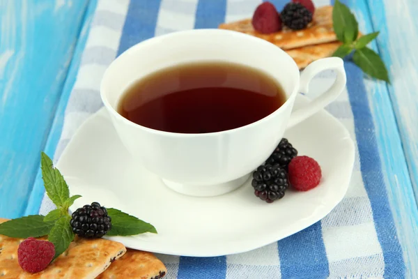 Cup of tea with cookies and berries on table close-up — Stock Photo, Image