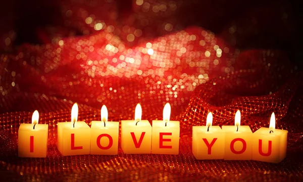 Candles with printed sign I LOVE YOU, on bright background — стоковое фото