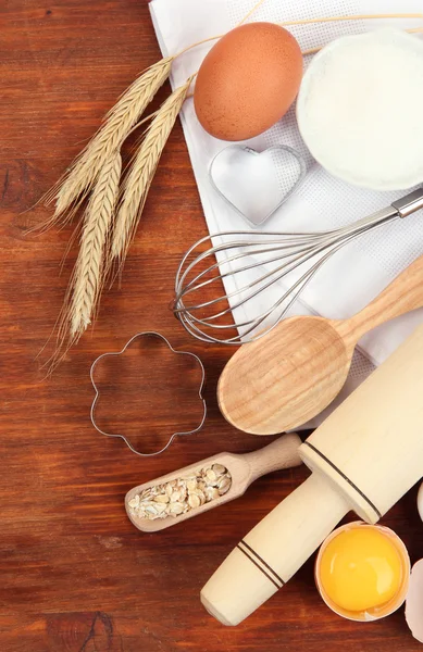 Conceito de cozinha. Ingredientes básicos de cozimento e utensílios de cozinha na mesa de madeira — Fotografia de Stock