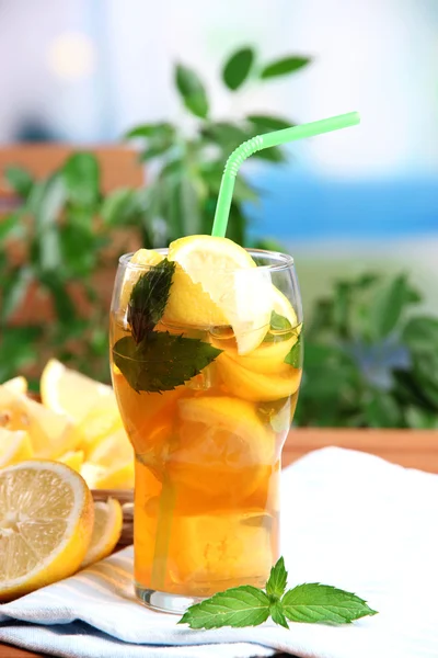 Té helado con limón y menta en la mesa de madera, al aire libre —  Fotos de Stock