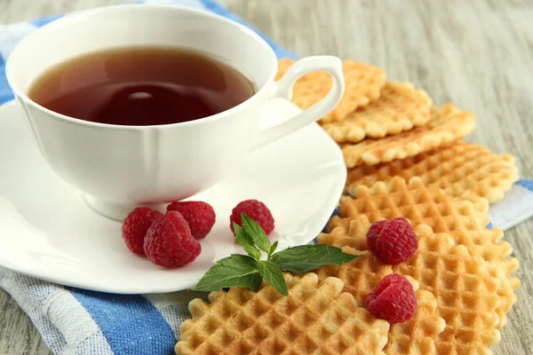 Taza de té con galletas y frambuesas en primer plano de la mesa —  Fotos de Stock