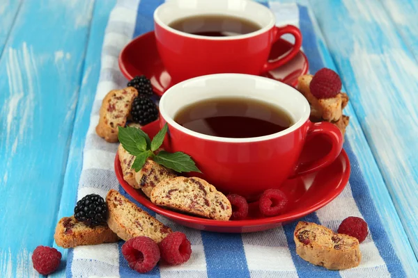 Tazze di tè con biscotti e bacche sul tavolo primo piano — Foto Stock