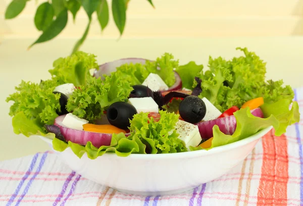 Řecký salát na talíři na tabulce na světlé pozadí — Stock fotografie