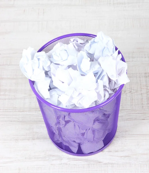 Recycle bin filled with crumpled papers, on floor — Stock Photo, Image