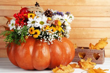 Beautiful autumn composition in pumpkin with decorative box on table on wooden background clipart