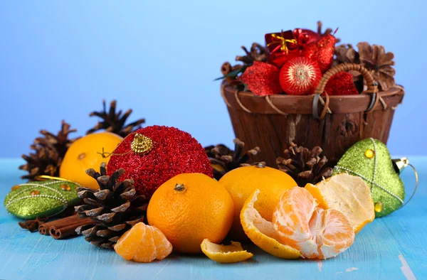 Christmas composition with tangerines on wooden table on blue background — Stock Photo, Image