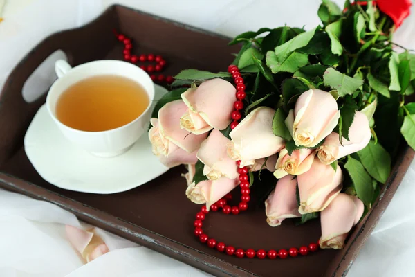 Rosas e chá na bandeja de madeira — Fotografia de Stock