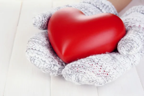 Vrouwelijke handen in wanten met hart — Stockfoto