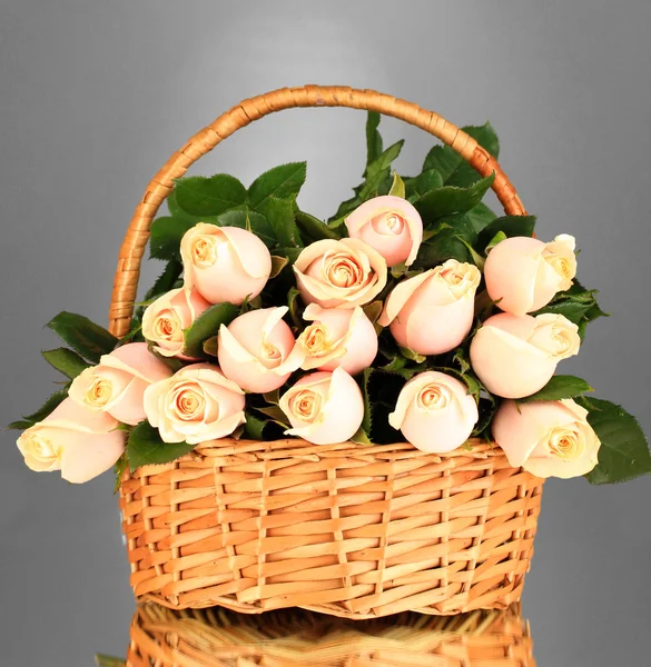 Vacker bukett av rosor i korg på grå bakgrund — Stockfoto
