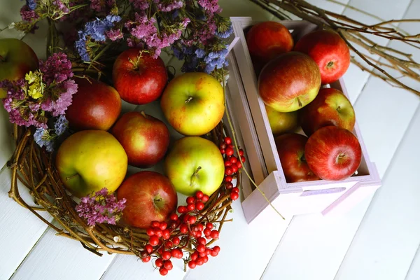 Saftige Äpfel in Schachtel auf weißem Holztisch — Stockfoto