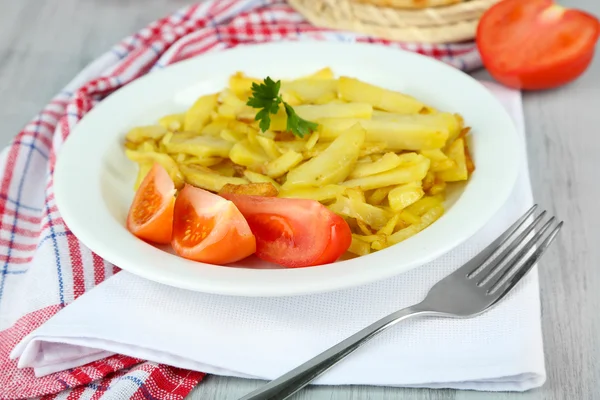 Gebakken aardappelen op plaat op houten tafel close-up — Stockfoto