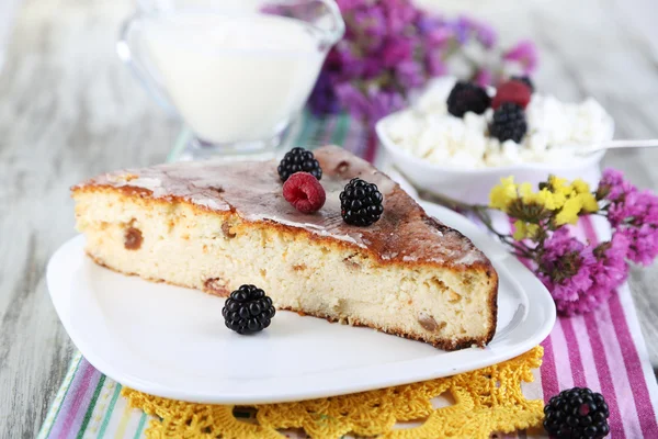 Cheese casserole with raisins on plate on napkin on wooden table close-up — Stock Photo, Image