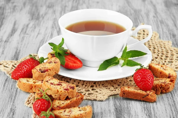 Filiżanka herbaty z ciasteczkami i truskawkami na stole zbliżenie — Zdjęcie stockowe