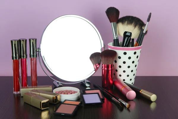 Round table mirror with cosmetics on table — Stock Photo, Image