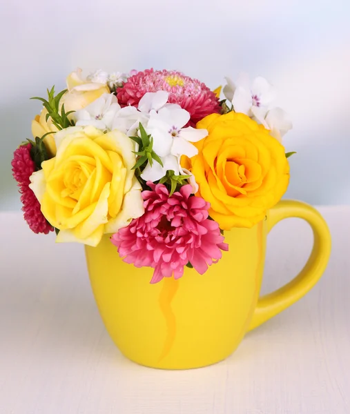 Bouquet in color mug on wooden table — Stock Photo, Image