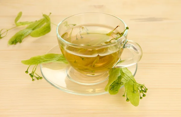 Glass cup of tea with linden on wooden table close-up — Stock Photo, Image