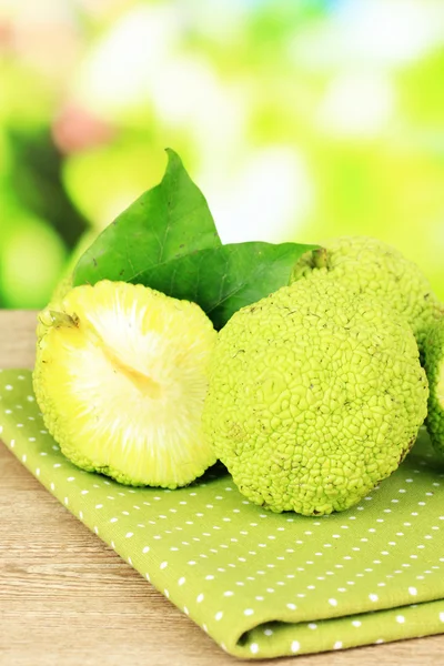 ผลส้มโอเซจ (Maclura pomifera) บนโต๊ะไม้ บนพื้นหลังธรรมชาติ — ภาพถ่ายสต็อก