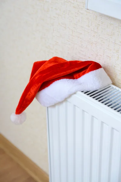 Red Christmas hat on white radiator — Stock Photo, Image