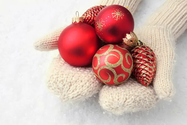 Mani femminili in guanti Albero di Natale palle, su sfondo di colore — Foto Stock