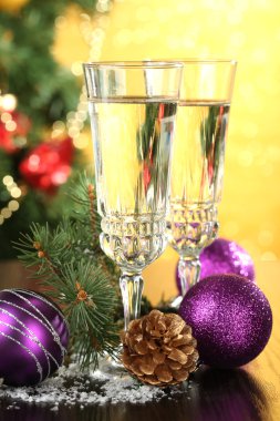 Yılbaşı süsleri ve parlak zemin üzerine iki şampanya bardağı kompozisyonu