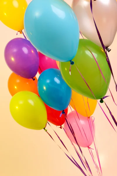 Veel heldere ballonnen op oranje achtergrond — Stockfoto