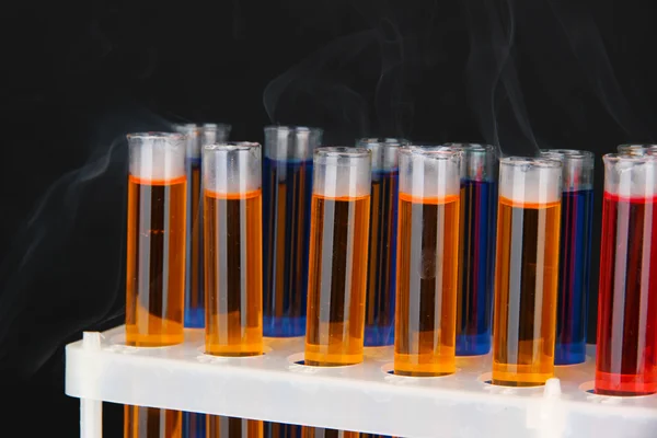 Tubos de ensaio de laboratório sobre fundo preto — Fotografia de Stock
