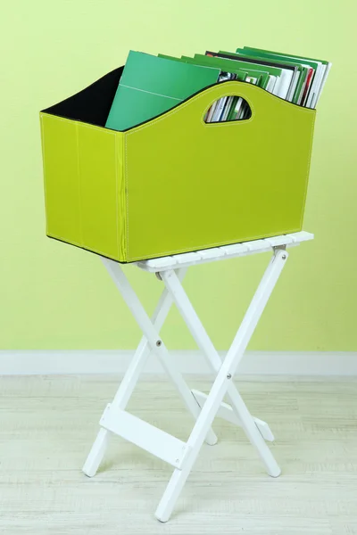 Magazines and folders in green box on table in room — Stock Photo, Image