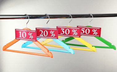 gri arka plan üzerinde Satılık sembolü olarak ahşap Giyim Askıları