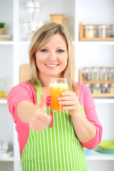 Gelukkig glimlachende vrouw in de keuken het bereiden van vers fruit cocktail — Stockfoto