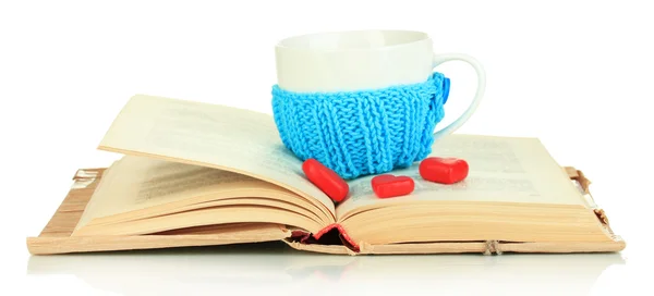 Cup with knitted thing on it and open book isolated on white — Stock Photo, Image