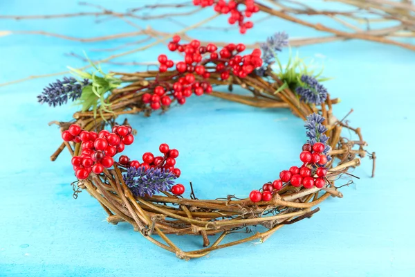 Wreath of dry branches with flowers and viburnum on wooden table close-up — Stock Photo, Image