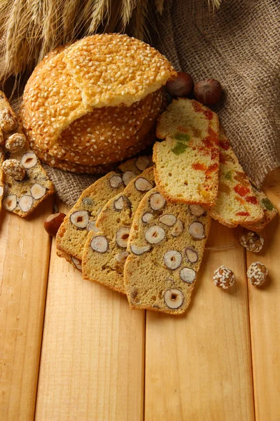 Domácí sušenky se sezamem a italské sušenky, na dřevěný stůl, na pozadí pytloviny — Stock fotografie