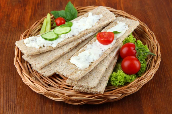 Välsmakande torrt bröd med grönsaker på trä bakgrund — Stockfoto