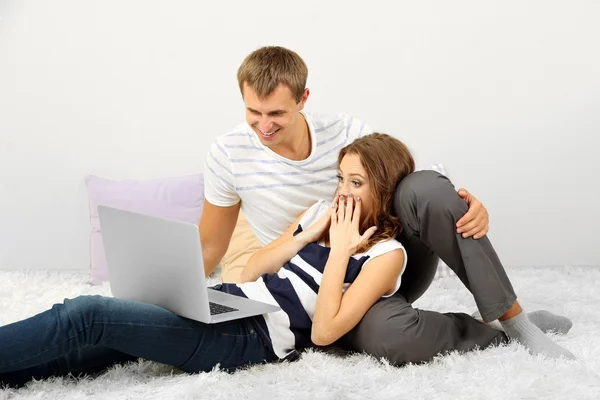 Gelukkige jonge paar met laptop thuis — Stockfoto