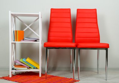 modern renkli sandalyeler, ahşap stand, duvar fon üzerine kitap ile güzel iç