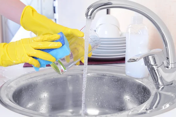 Mani di donna che lava piatti in cucina — Foto Stock