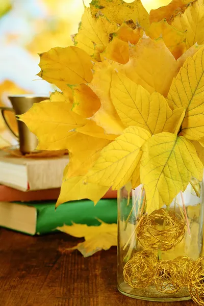 Feuilles d'automne lumineuses dans un vase sur une table en bois — Photo