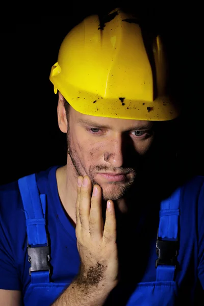 Portrait of young worker on dark background — Stock Photo, Image