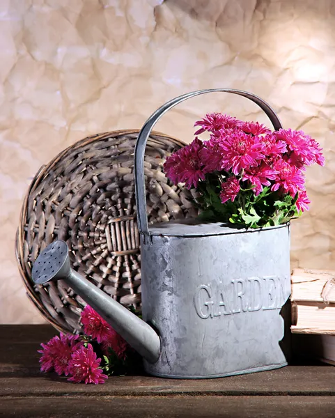 Boeket van roze chrysant in gieter op houten tafel — Stockfoto