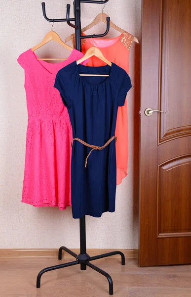 Dresses hanging on hanger near door — Stock Photo, Image