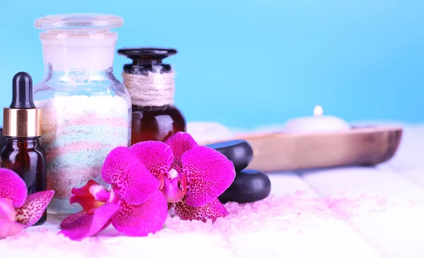 Beautiful spa setting with orchid on white wooden table on blue background — Stock Photo, Image