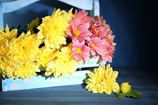 Bellissimi fiori nel cestino, su sfondo di legno scuro — Foto Stock